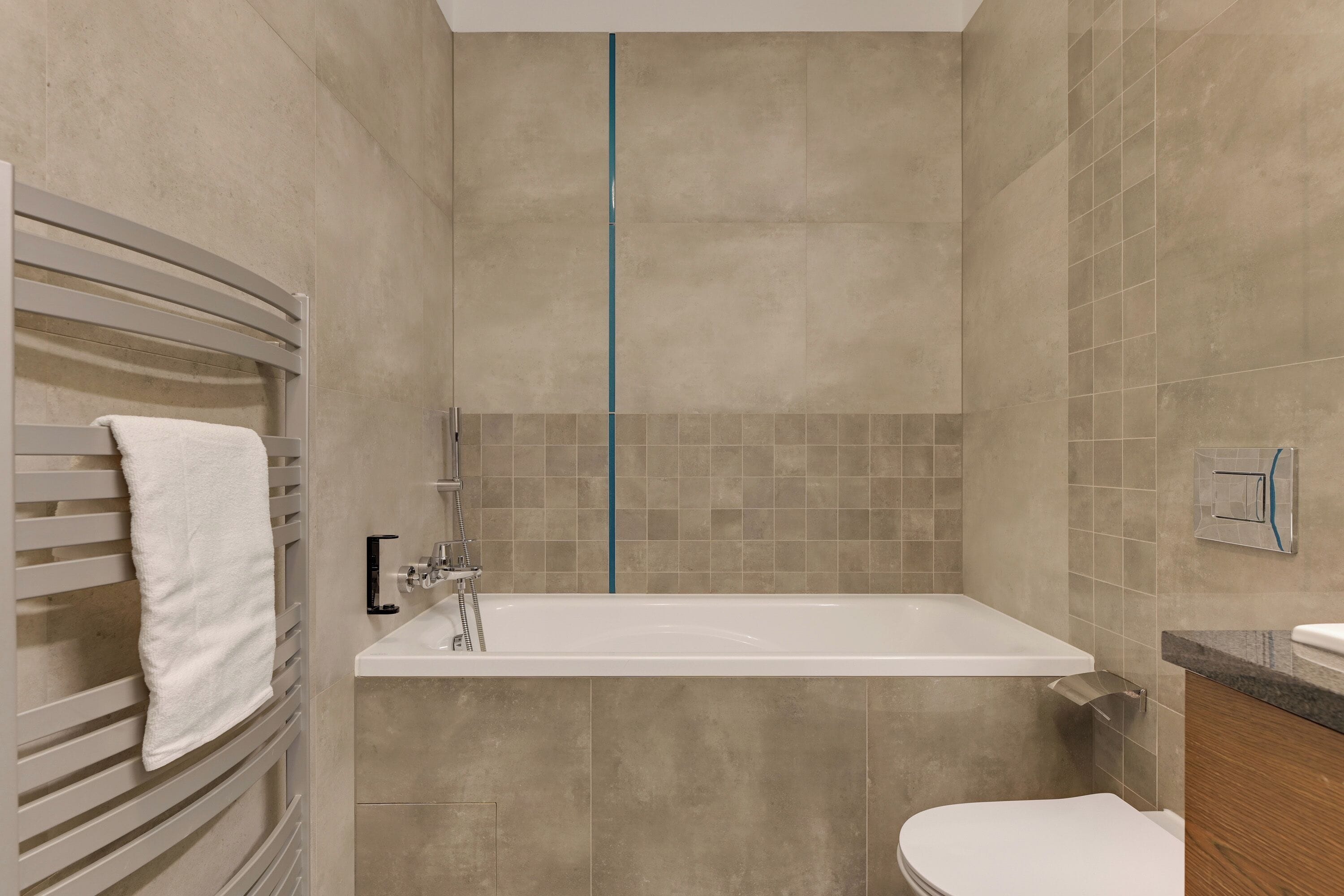 Un baño moderno con bañera, inodoro y barra para toallas.