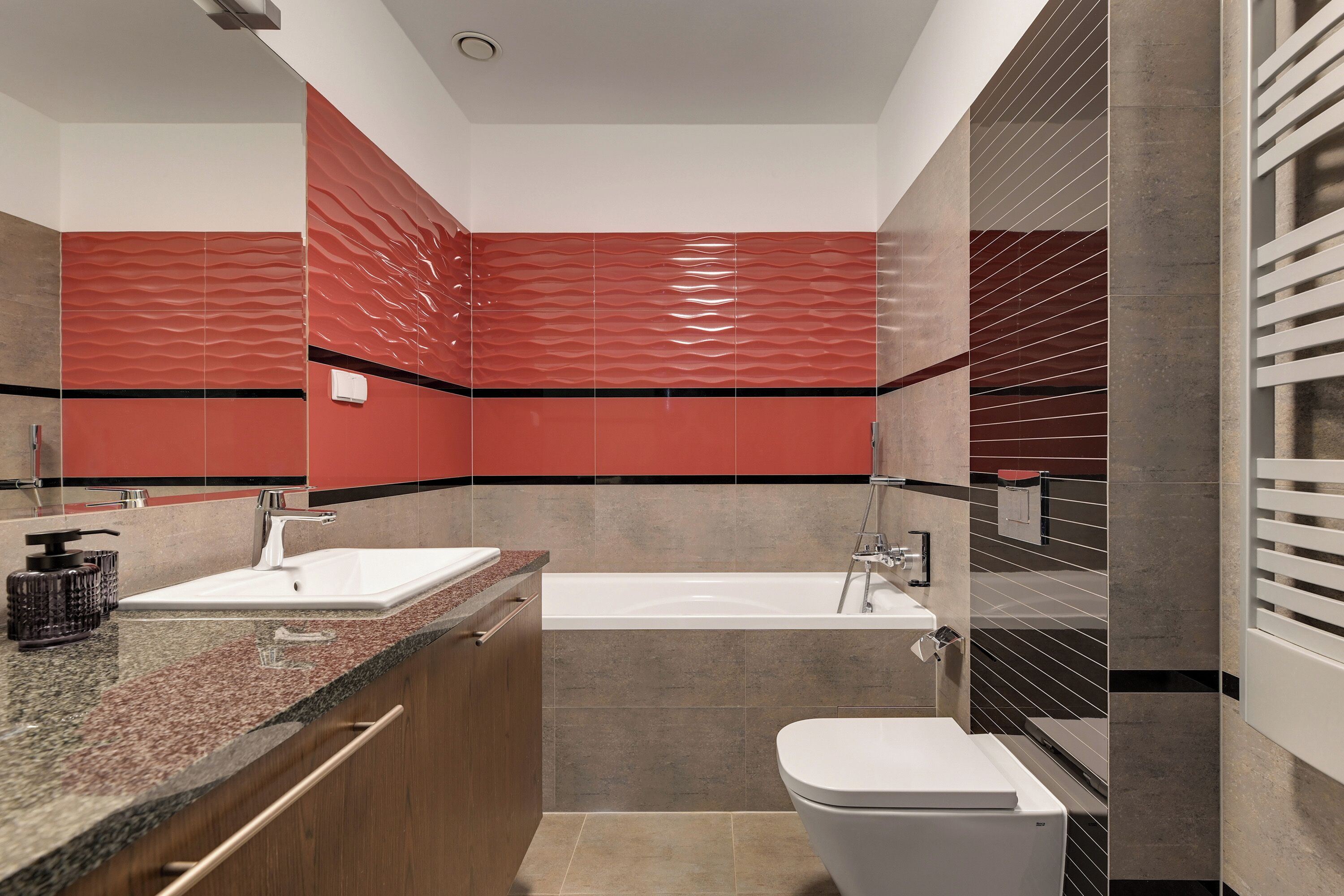 Een moderne badkamer met een wit wastafel, een bad en een toilet.