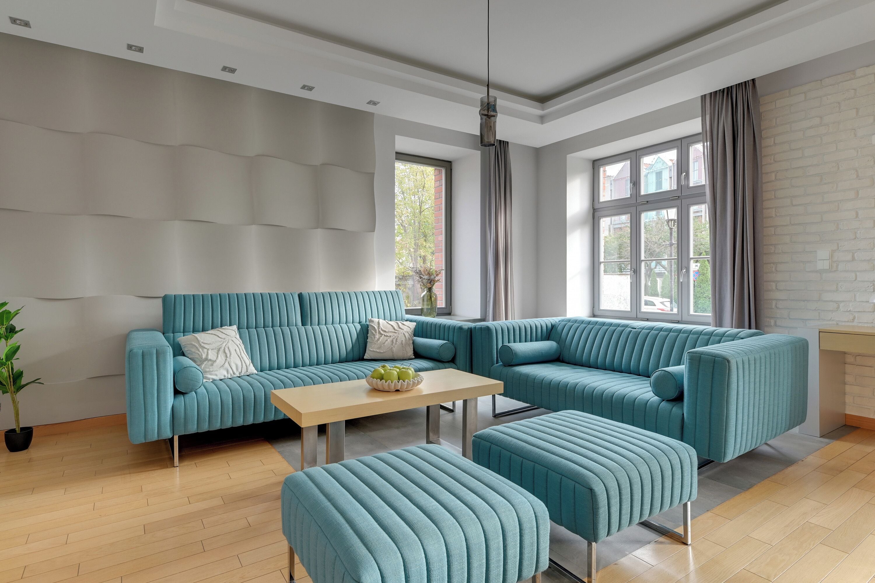 Een moderne woonkamer met een hoekbank, een salontafel en een bijpassend poef.
