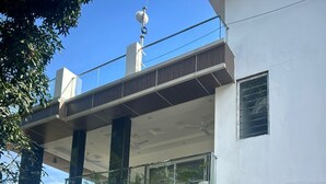 Un edificio di due piani con un balcone, ampie finestre e un condizionatore d'aria a vista.