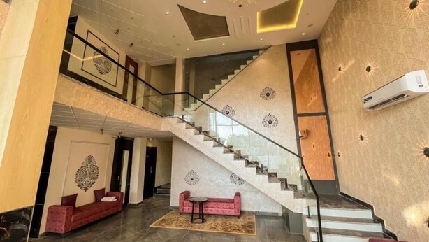 Eine geräumige Lobby mit einer imposanten Treppe, einem Kronleuchter und einem modernen Design.