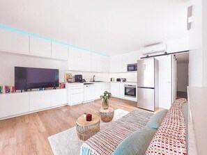 Eine moderne Wohnung mit Küche, Wohnbereich und einer Couch.