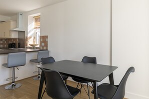 A modern kitchen with a dining area. - Cosy 1-Bed Flat Next to Metro (Greater London)