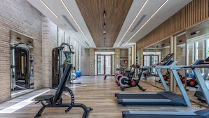 Ein Fitnessstudio mit Laufbändern, Kraftgeräten und Trainingsbällen.