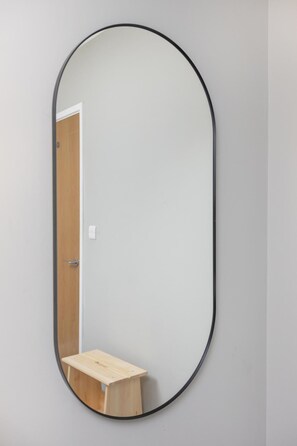 A mirror with a wooden stool in front of it. - Spacious 2-Bed Flat with Outdoor Patio (Greater London)