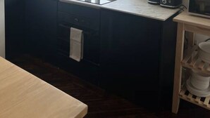 A compact kitchen with a window, a microwave, a toaster, and a sink. - Spacious Duplex near Clapham (Greater London)