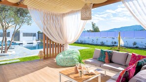 Ein luxuriöser Außenbereich mit Pool, bequemen Sitzmöglichkeiten und Blick auf die Berge.