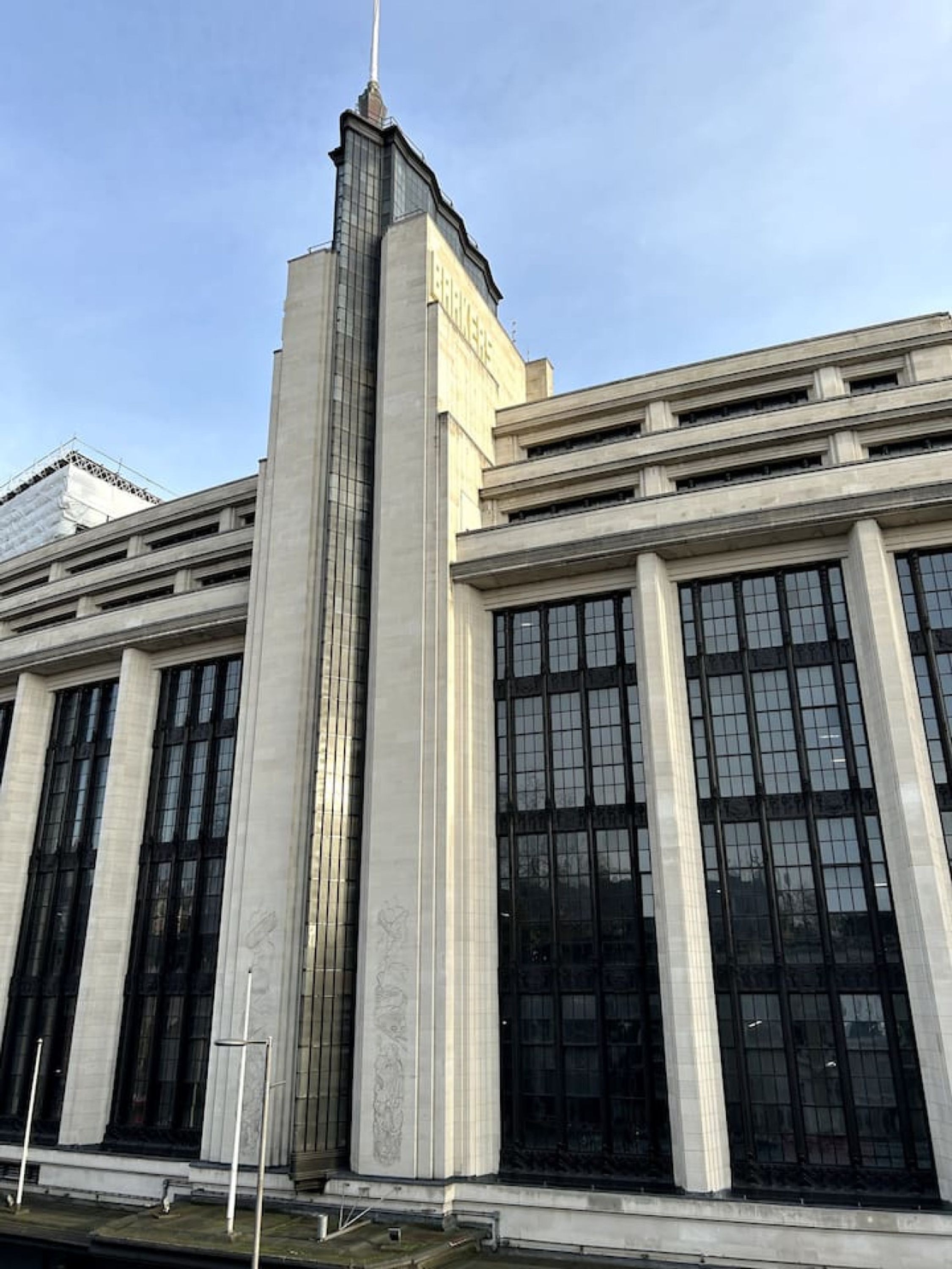 A large, modern building with a prominent central tower and multiple large windows.