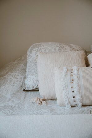 Un lit avec une literie à motifs et des coussins décoratifs.