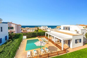 A modern resort with a pool, sun loungers, and a view of the sea. - Villa Dreams by Villa Plus (Los Delfines)