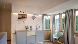 Una cocina moderna con una isla integrada, una cafetera y una lámpara colgante.