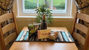 A wooden table with a bottle of champagne, a glass, and a box of strawberries. - New - Chapter House Retreat! 3 minutes walk to The Minster area! (York)