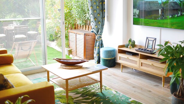A living room with a large TV, wooden furniture, and a view of a garden. - Just 50 meters from the Marines de Cogolin beach! (Cogolin)