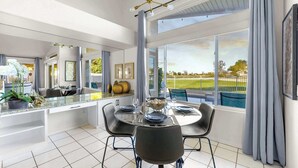 Un comedor moderno con una mesa de vidrio, sillas negras y un cuenco decorativo en el centro.