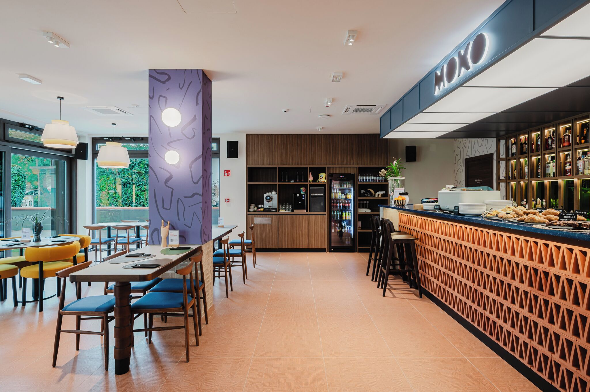 A modern restaurant interior with a bar area, seating arrangements, and a visible counter.