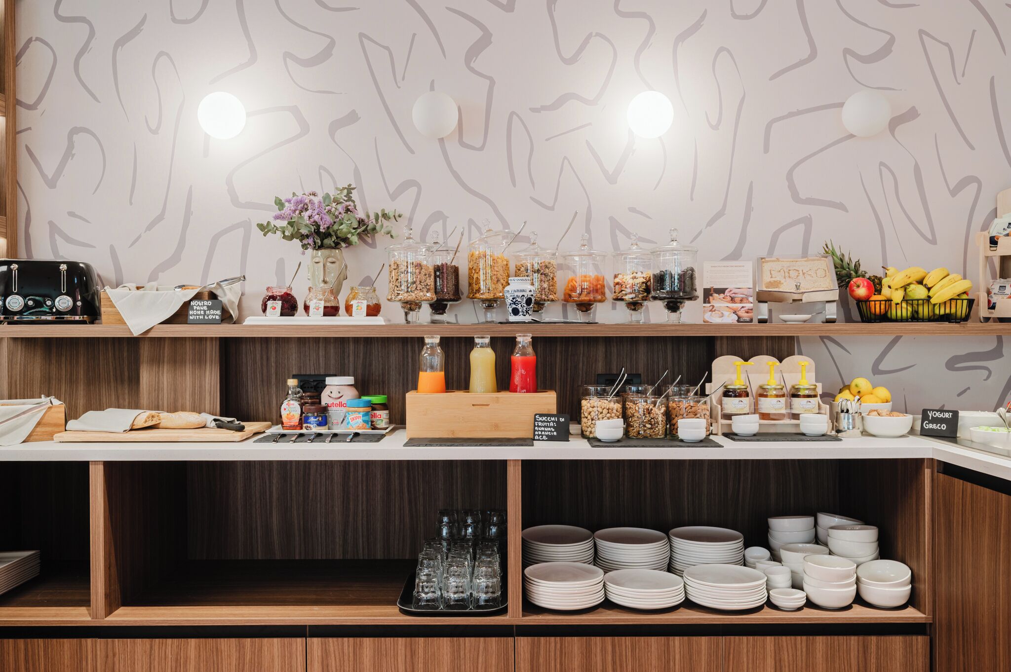 A breakfast bar with various food items, condiments, and a toaster.