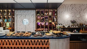 A buffet counter with various pastries and a selection of beverages.