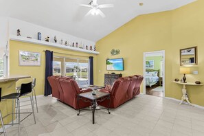 A room with a dining area, a TV, and a bed. - Tipsy Turtle | 4BR/2 BA l Heated Pool | Sleeps 8 (Cape Coral)