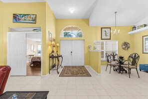 A spacious living area with a dining set, a sofa, and a coffee table. - Tipsy Turtle | 4BR/2 BA l Heated Pool | Sleeps 8 (Cape Coral)