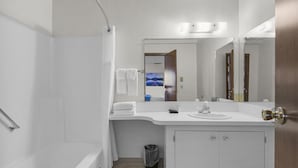 Ein modernes Badezimmer mit Dusche, Waschbecken und Spiegel.