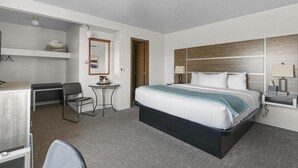 Ein Hotelzimmer mit Bett, Schreibtisch, Stuhl und einem kleinen Tisch.