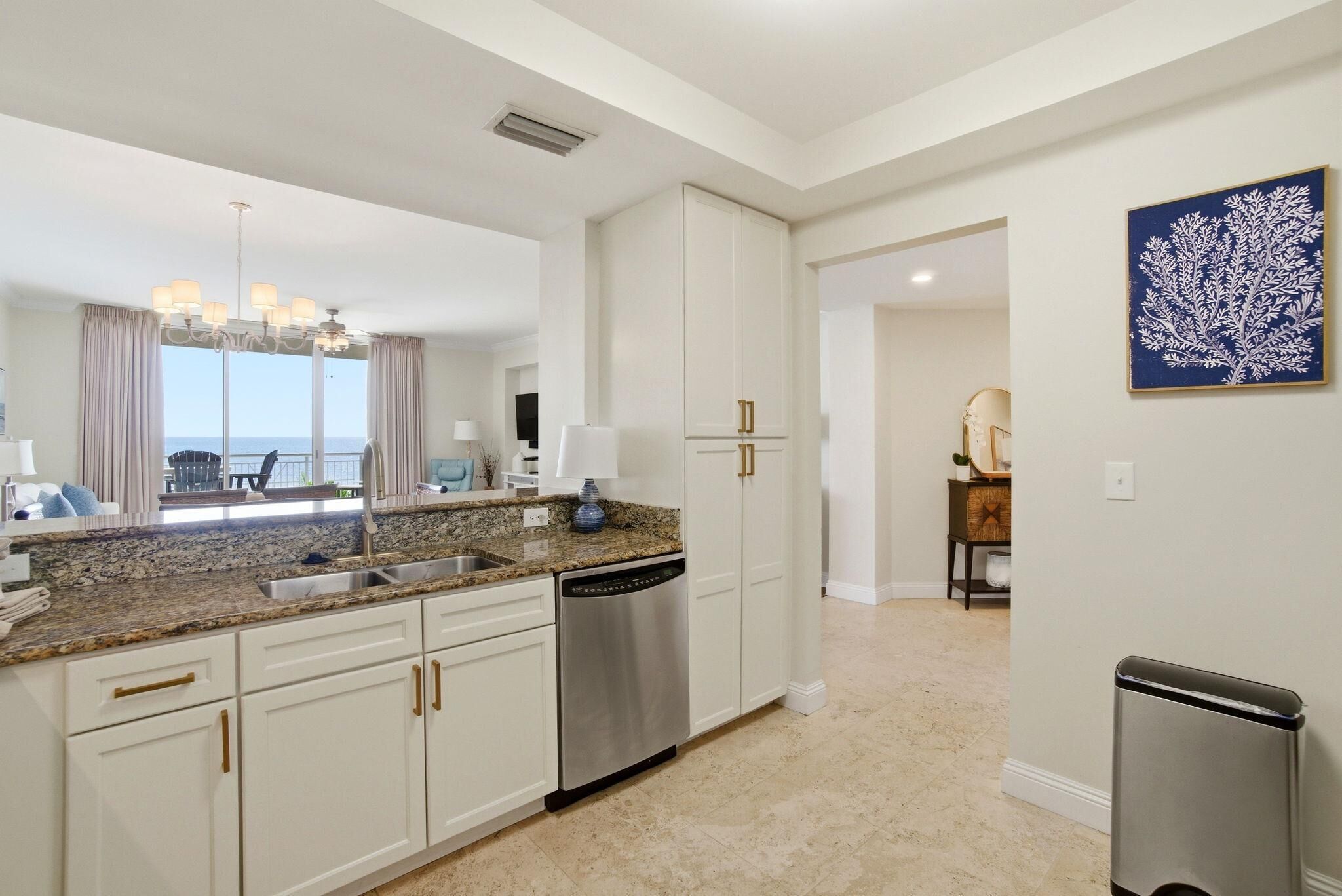 A modern kitchen with white cabinets, stainless steel appliances, and a granite countertop.