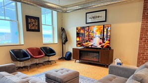 Una sala de estar acogedora con chimenea, asientos cómodos y un televisor grande.