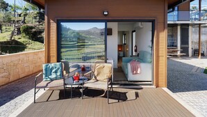 Een modern gebouw met een balkon, een eethoek en uitzicht op het platteland.