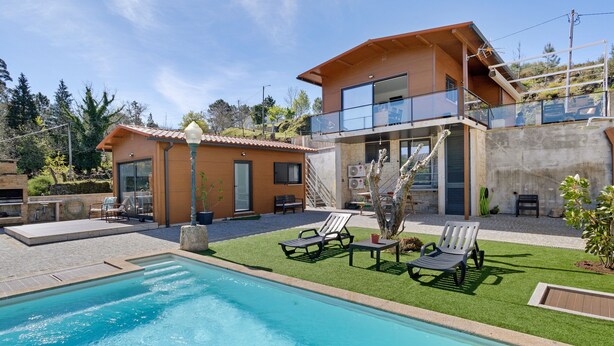 A modern two-story house with a swimming pool, outdoor seating, and a stone wall. - Holiday Home 'Casa Dona Florinda - Ermida, Pnpg' with Shared Pool, Shared Garden and Wi-Fi (Ermida)