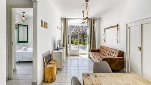 A modern interior with a dining area, a sofa, a desk, and a view through a glass door. - Villa 'Masia Cal Ros' with Mountain Views, Wi-Fi, and Air Conditioning (S'Agaró)