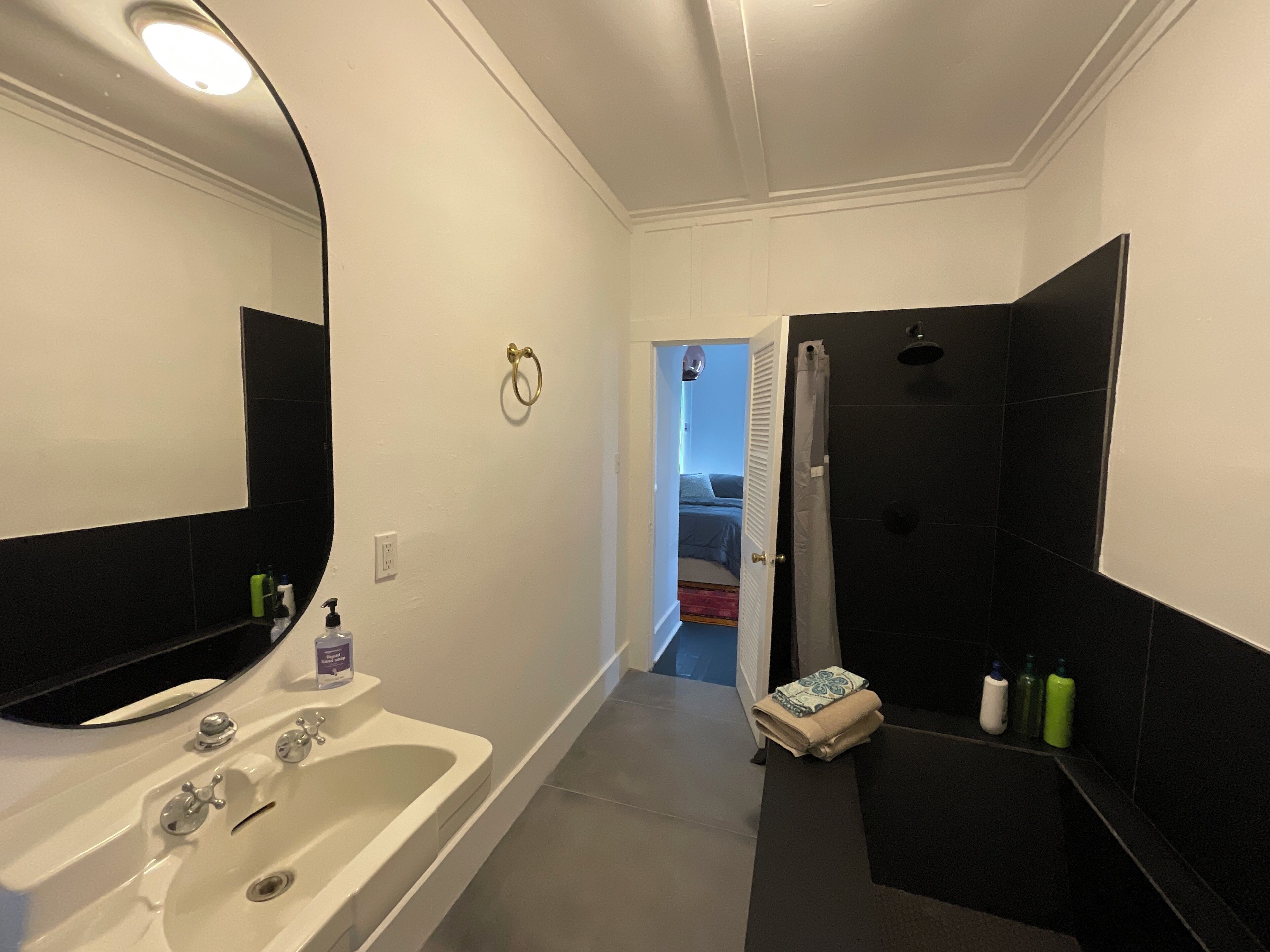 A modern bathroom with a white sink, a bathtub, and a shower area.