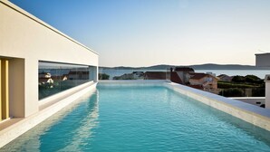 A rooftop swimming pool with a clear view of the sea and surrounding buildings. - Apartment with rooftop pool A2, Bibinje (Bibinje)