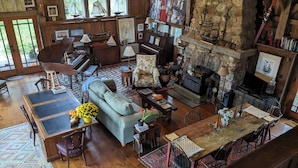 Un amplio salón con chimenea, muebles de madera y una pared de piedra.