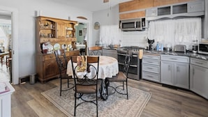 A kitchen with a dining area, wooden cabinets, a microwave, and a ceiling fan. - Pet-friendly Historic 4BR Home in Illinois (Lynn Center)