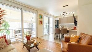 Un salon moderne comprenant un canapé, une table basse et un coin repas avec des chaises et une table.