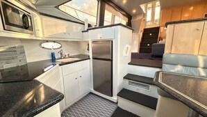 Eine kleine Küche mit Mikrowelle, Spüle und Kühlschrank.