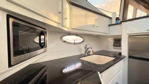 A compact kitchen with a sink, a stove, and a window.