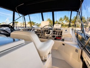 A boat's interior with a steering wheel, control panel, and seating area. - Waterfront Yacht • Sleeps 4 • Deck Dining• Pools & Bar Access • 15 Min Key West (Key West)