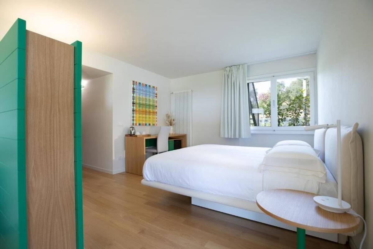 Ein modernes Schlafzimmer mit einem Bett, einem Schreibtisch und einem Fenster.
