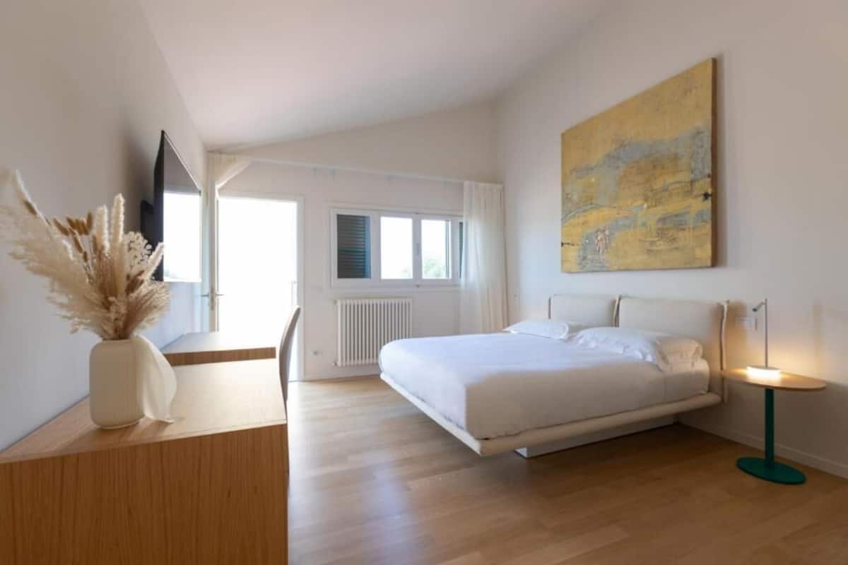 Ein modernes Schlafzimmer mit Bett, Nachttisch und einem Bild an der Wand.