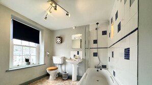 Un baño con inodoro, lavabo, bañera y ducha.
