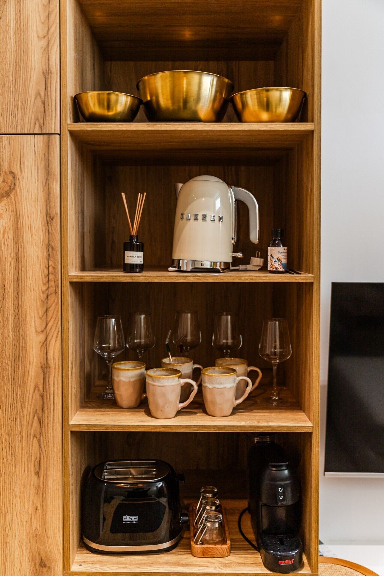 A wooden shelf with kitchenware, a coffee maker, and a toaster.