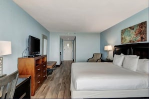 A hotel room with a bed, a television on a wooden cabinet, a chair, a desk, and a painting on the wall. - Inviting Bayside Studio With Bay View on Sandestin (Miramar Beach)