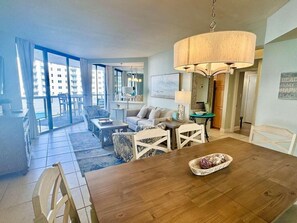 Ein geräumiger Wohnbereich mit Esstisch, Sofa und einem Balkon mit Blick auf die Stadt.