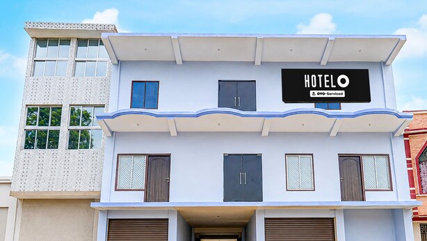 A two-story hotel with a sign reading 'HOTEL OYO-Serviced' on the upper level.