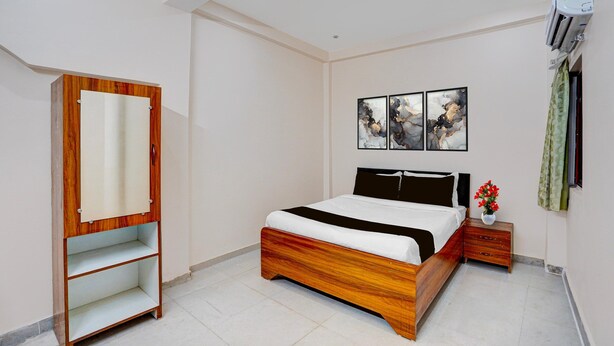 Une chambre à coucher avec un lit en bois, une armoire, une table de chevet et un climatiseur fixé au mur.