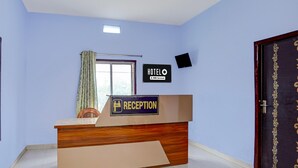 Un comptoir d’accueil d’hôtel avec une pancarte indiquant qu’il s’agit d’un hôtel OYO-Serviced.