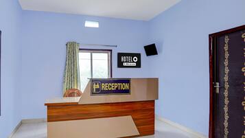 Een hotel receptie met een bordje waarop staat dat het een OYO-Serviced hotel is.
