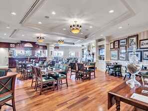 Eine großzügige Hotelhalle mit Holzböden, mehreren Sitzbereichen und einer Bar.