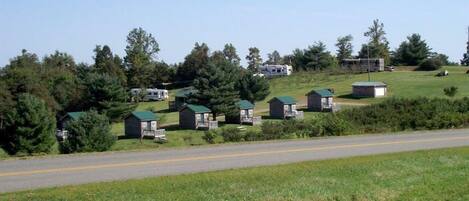 A rural road with small cabins on a hillside.